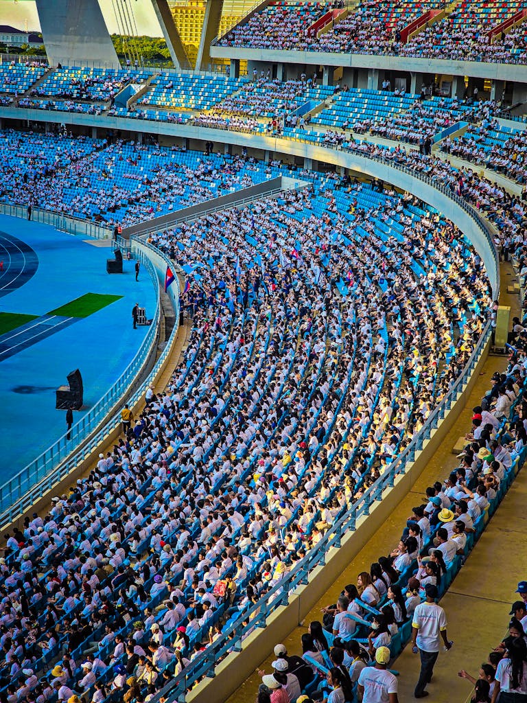 A lively crowd fills the stadium in Phnom Penh, Cambodia, during a daytime event.
