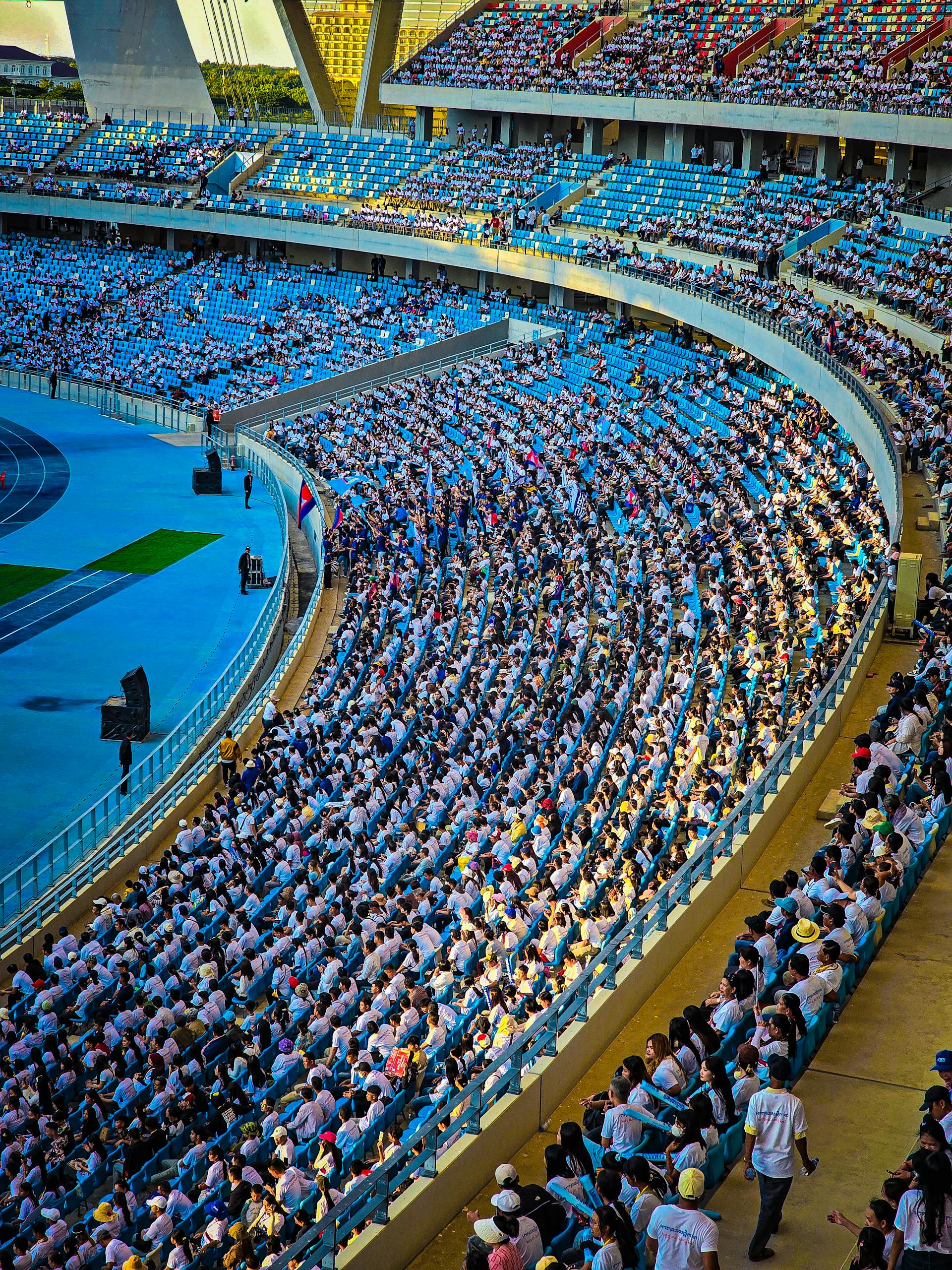 A lively crowd fills the stadium in Phnom Penh, Cambodia, during a daytime event.