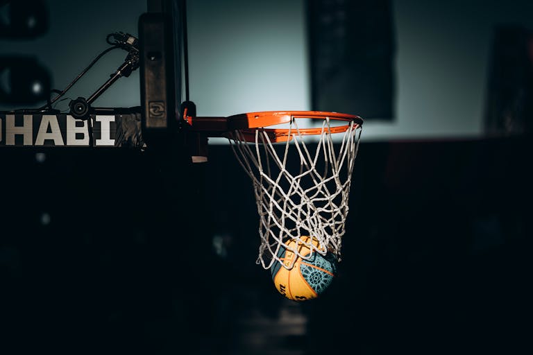 Dramatic basketball dunk captured in Abu Dhabi sports arena.