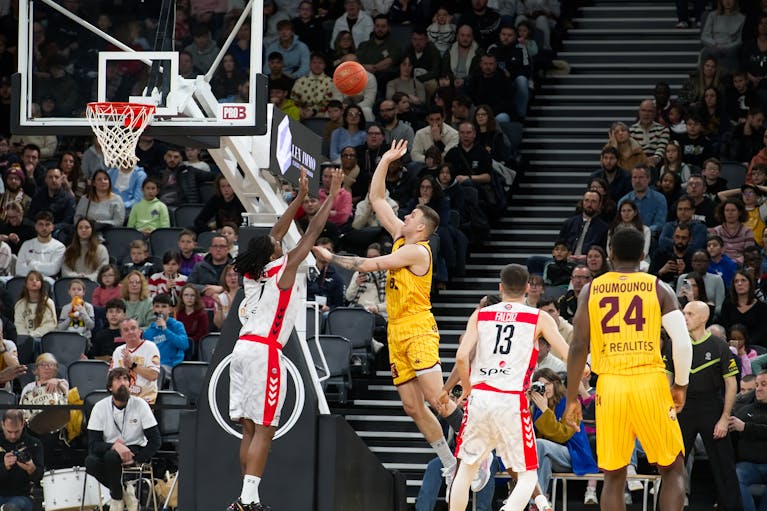 Dramatic moment in a basketball game with players and an engaged crowd.