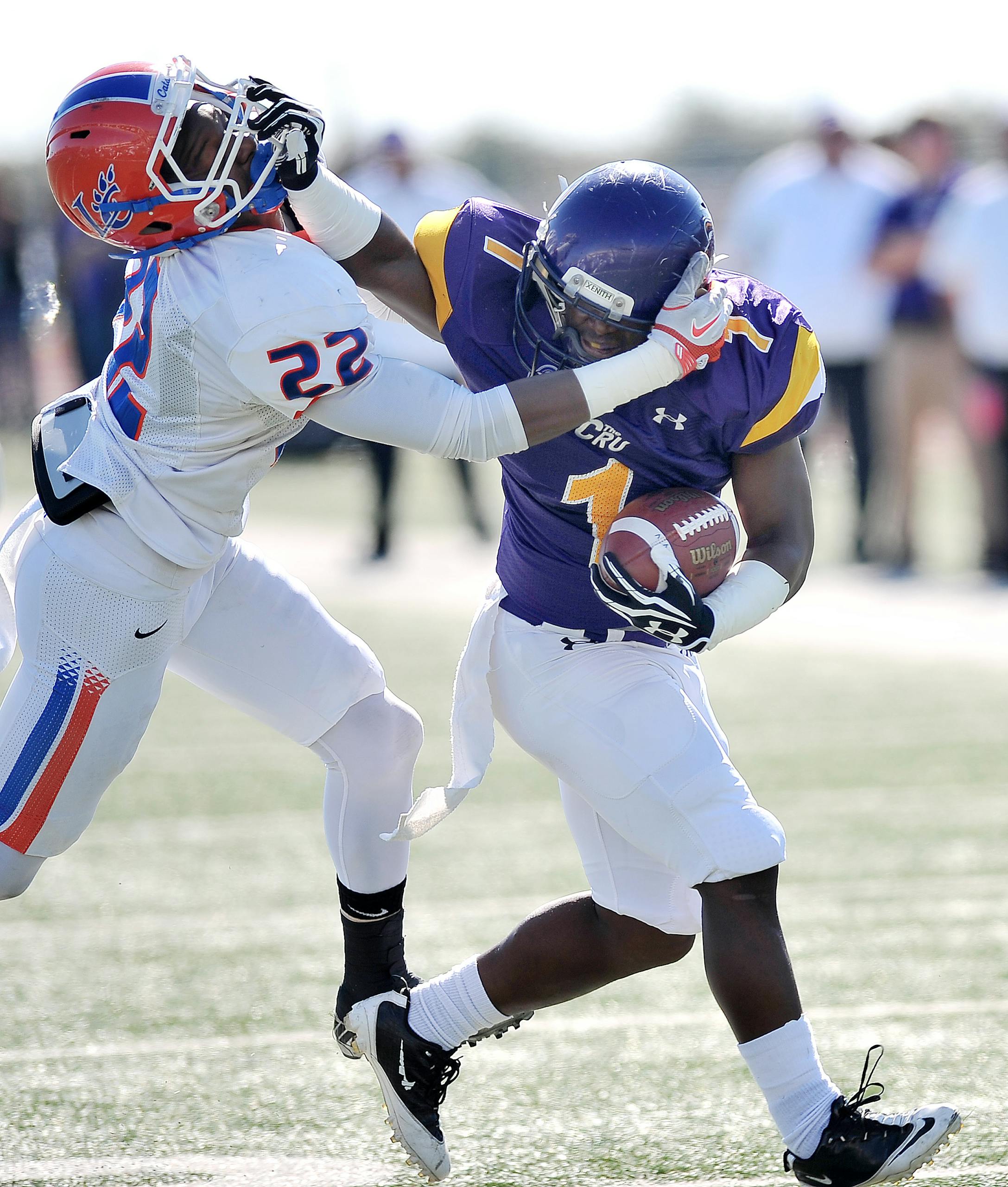 Dynamic action shot of American football players tackling during a competitive game outdoors.