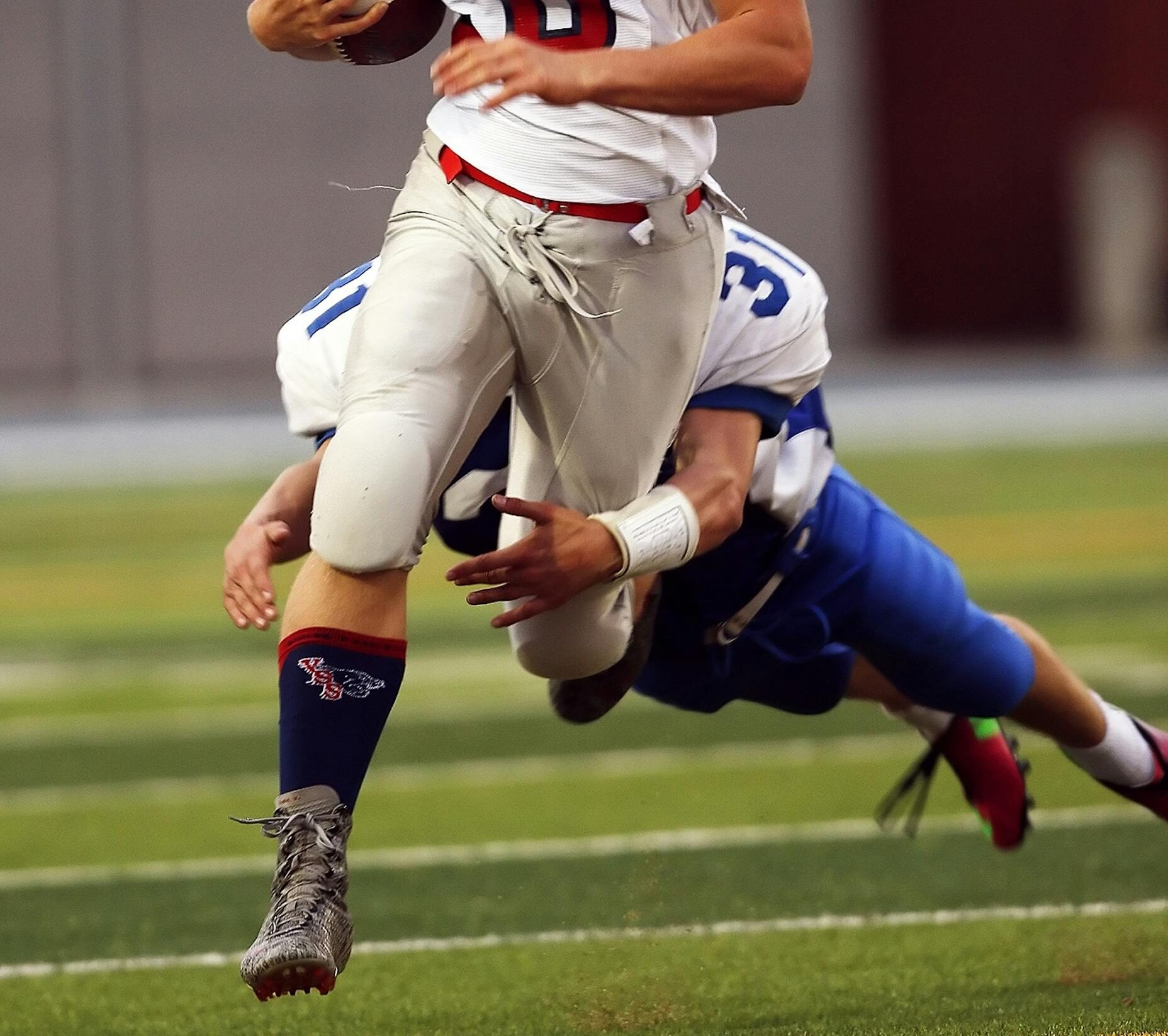 Dynamic shot of high school football players during a game, showcasing a quarterback in action.