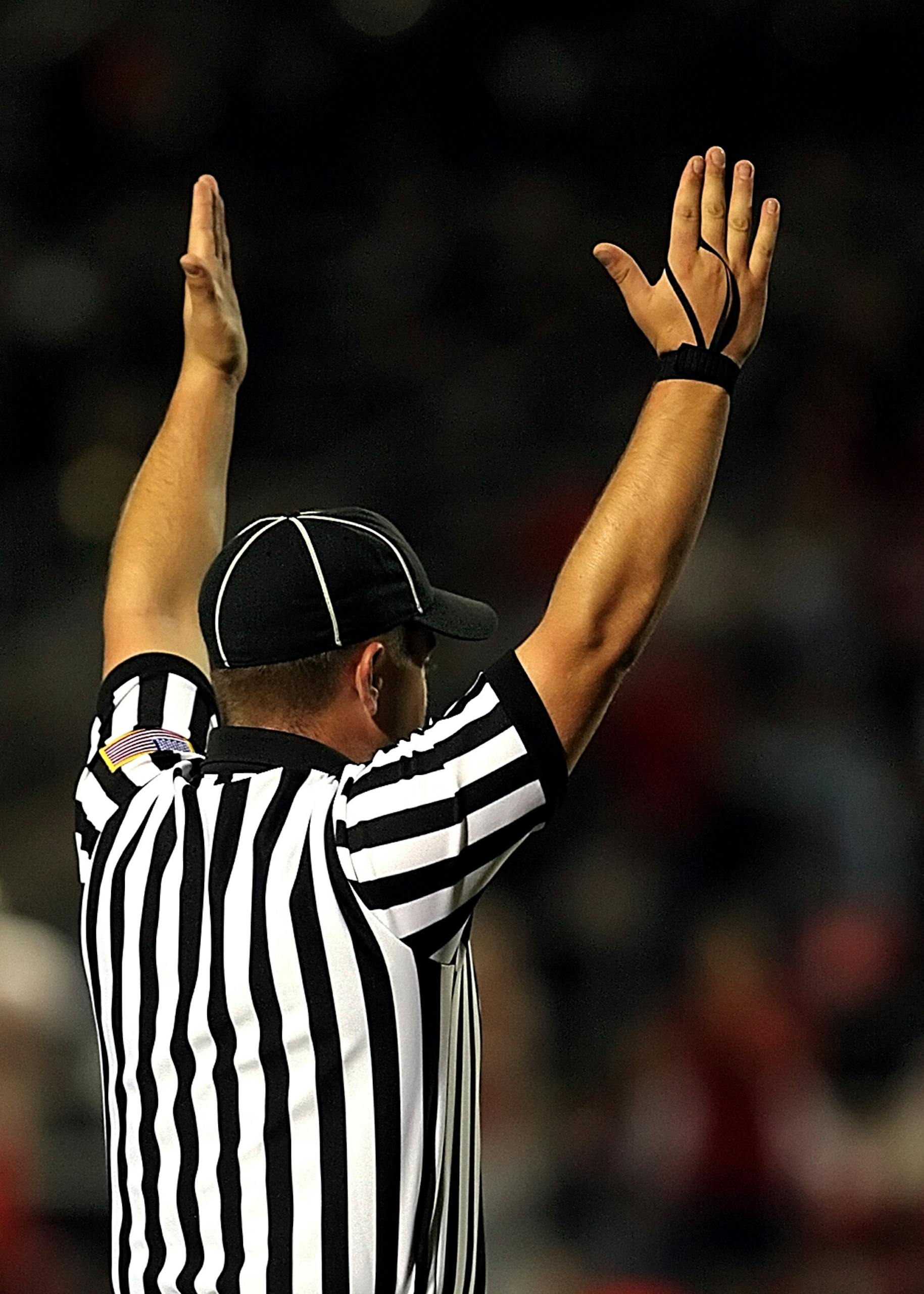 Referee raising hands to signal a goal or touchdown in a match.
