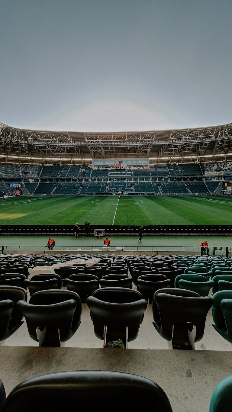 Wide-angle view of an empty football stadium, perfect for sports-themed projects.