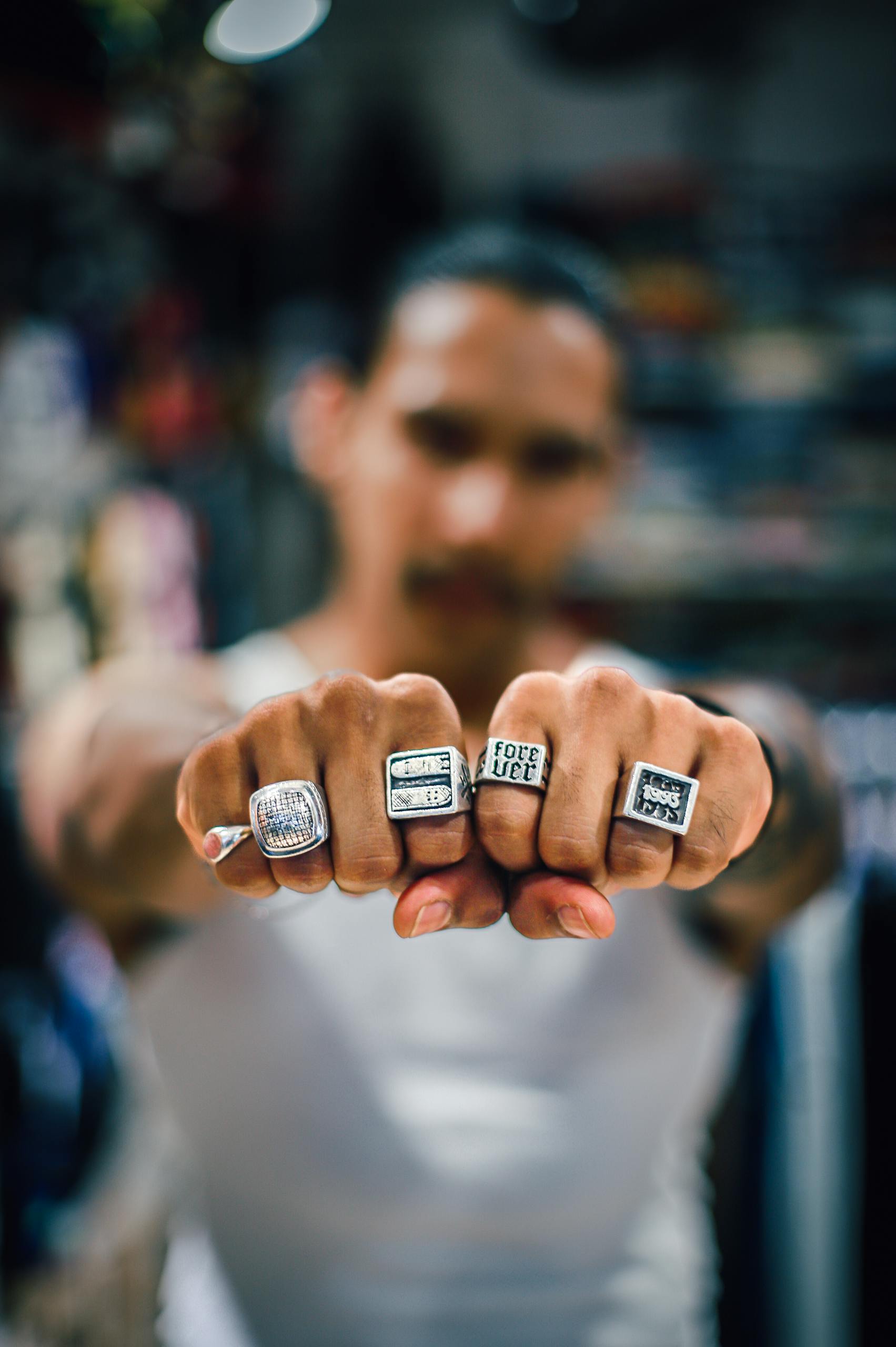 Young man displaying rings on his fingers with selective focus.