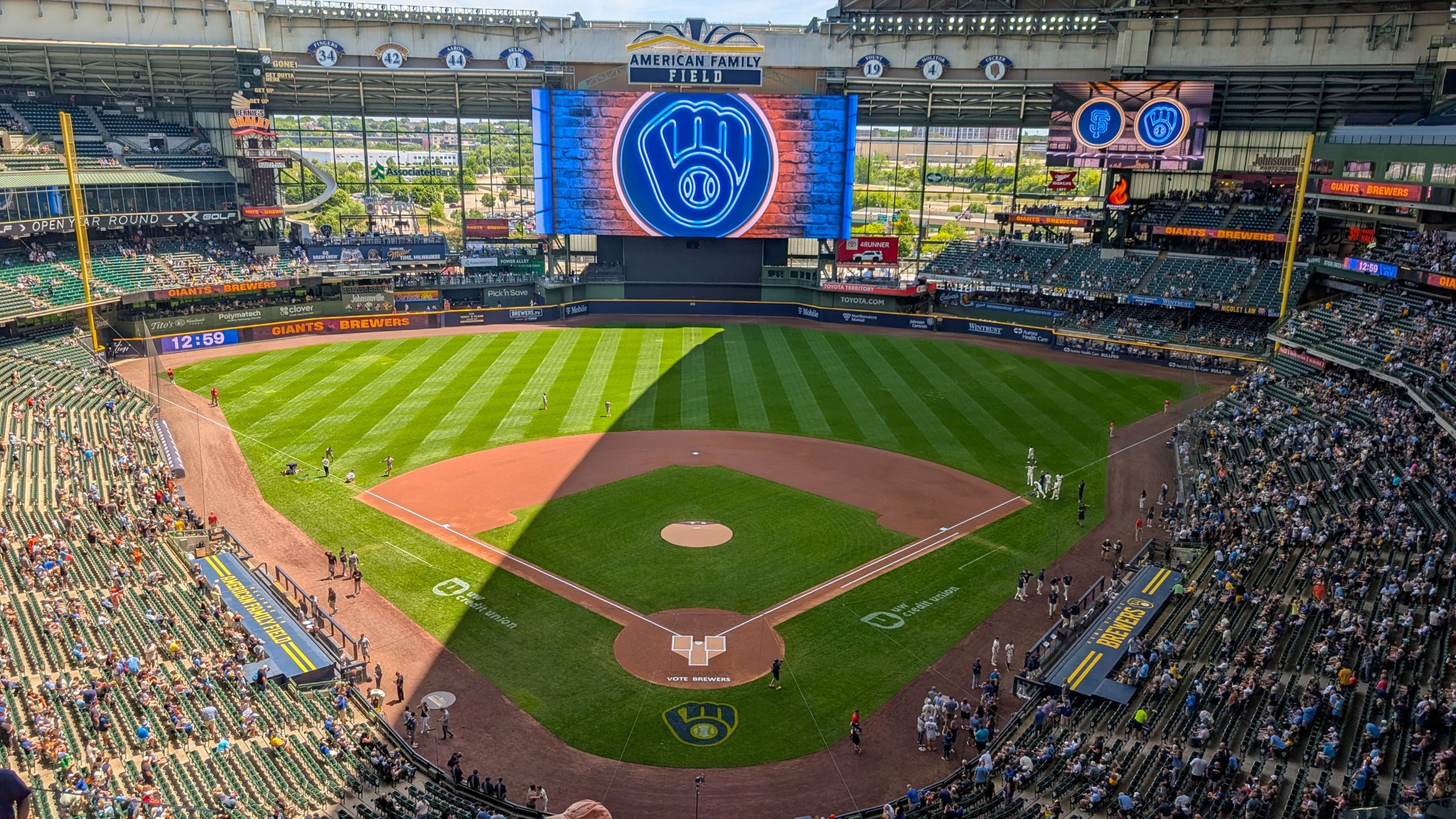 Aerial shot of American Family Field in Milwaukee during a daytime baseball game with clear skies.