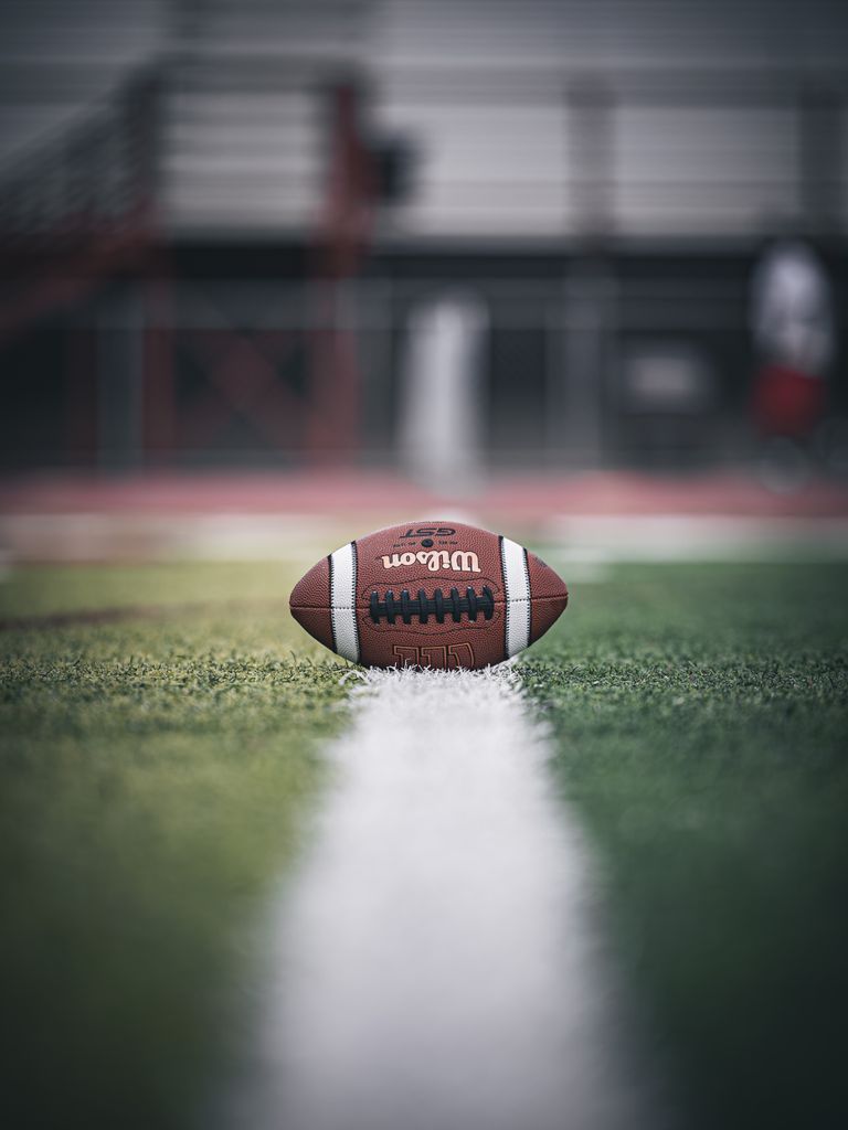 Close-up of an American football on the field, emphasizing the game atmosphere.