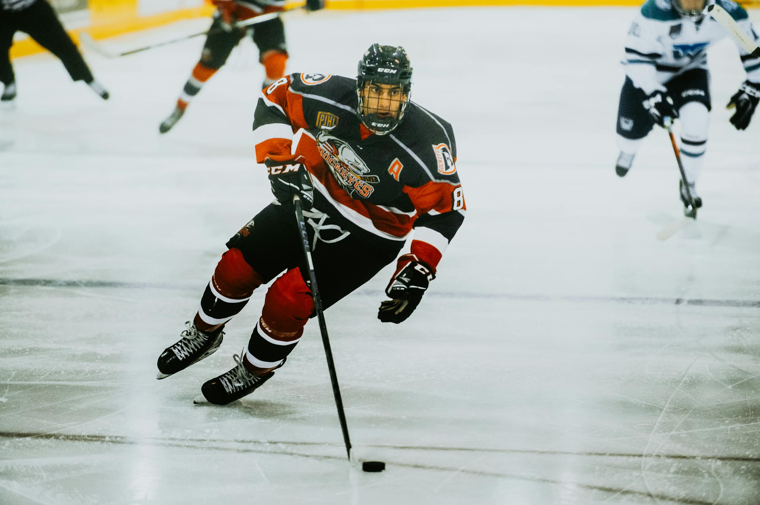 Dynamic action shot of a hockey player skating on an ice rink during a game.