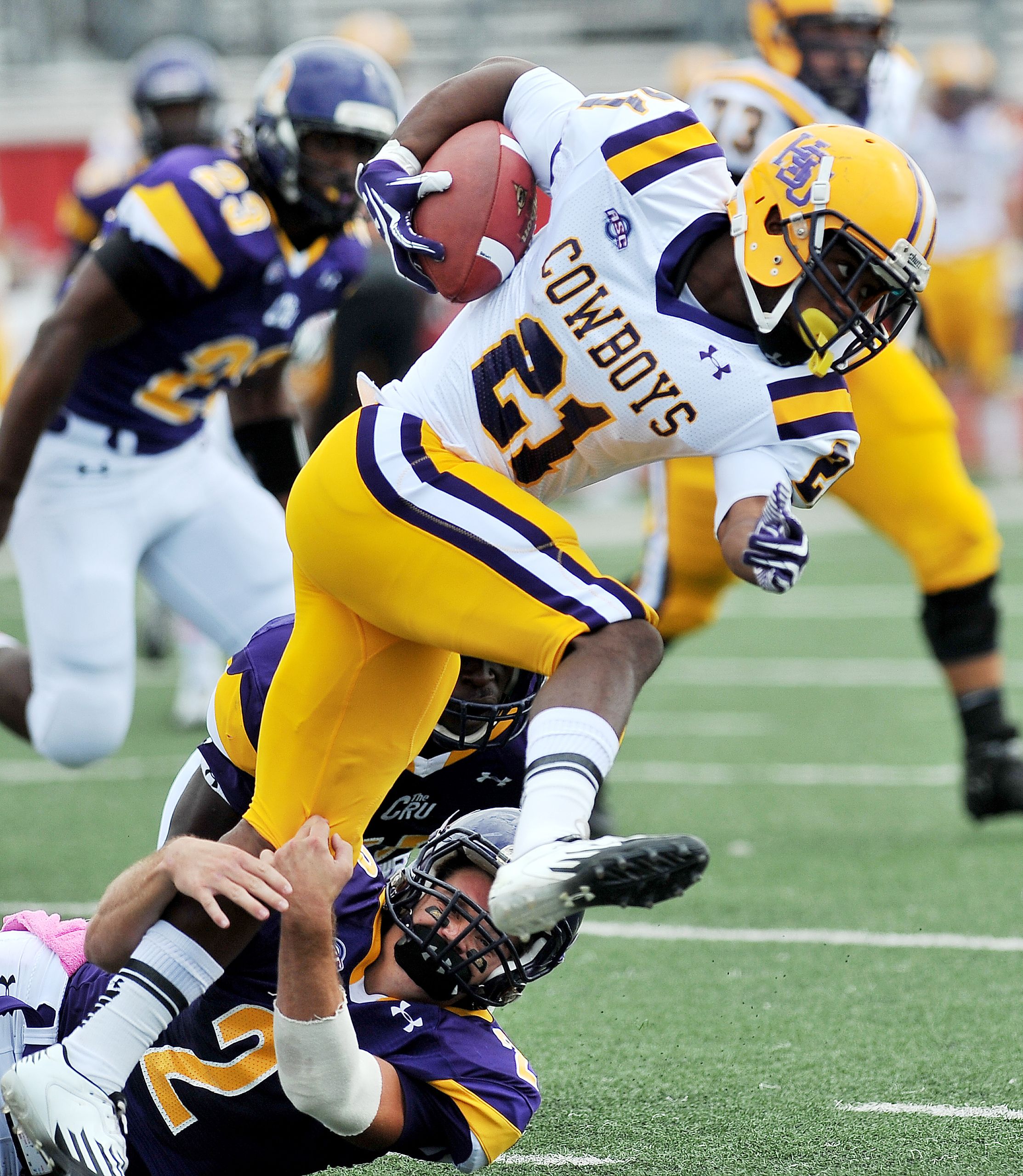 Explosive moment capturing a dynamic tackle in an American football game.
