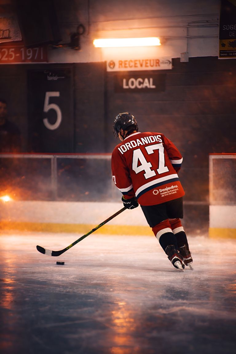 Intense ice hockey player in motion, showcasing competitive spirit on an indoor rink.