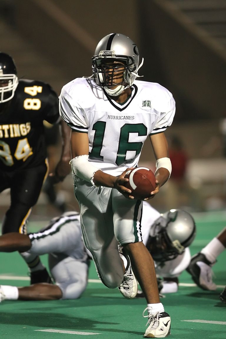 Intense moment of a quarterback preparing to pass during a game under bright stadium lights.