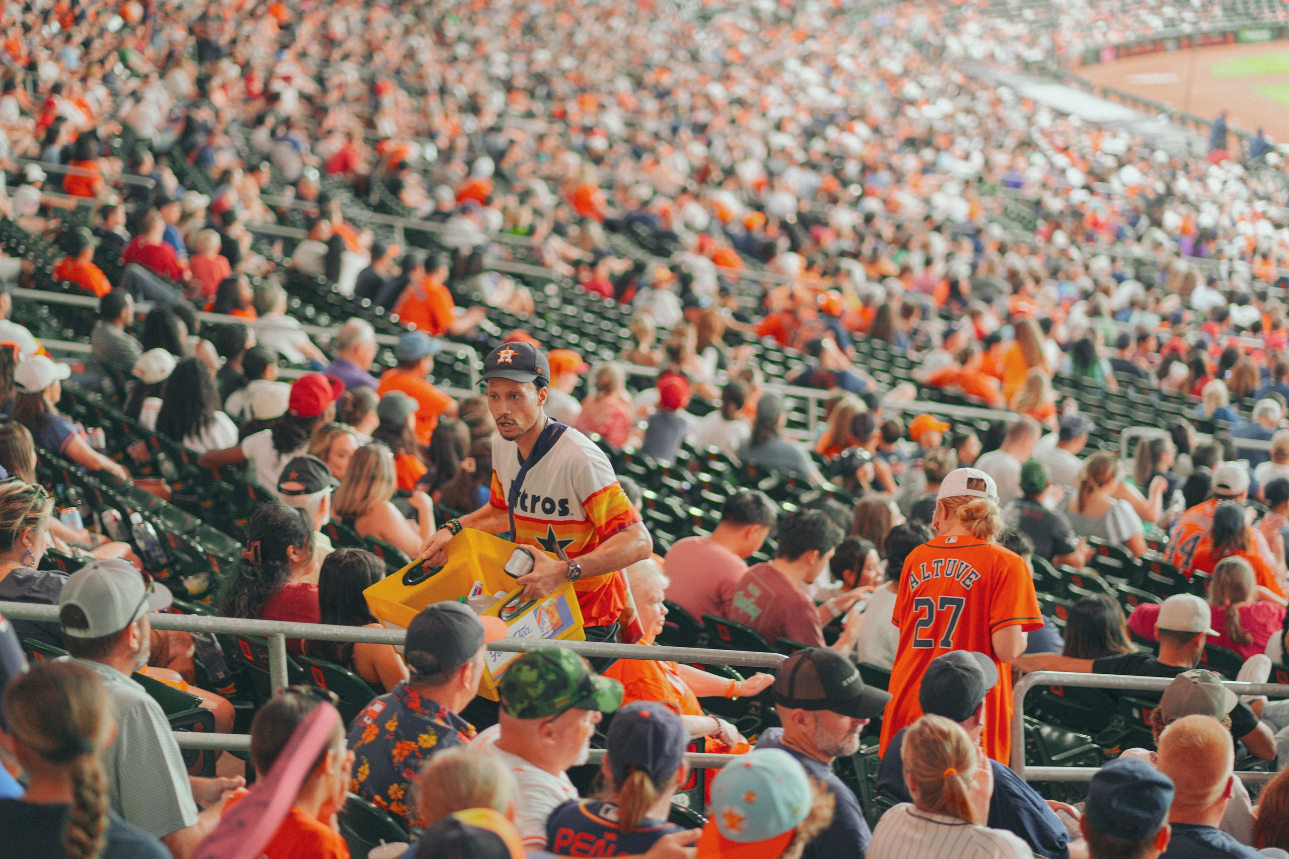 Packed Houston stadium featuring enthusiastic baseball fans during a major league game.