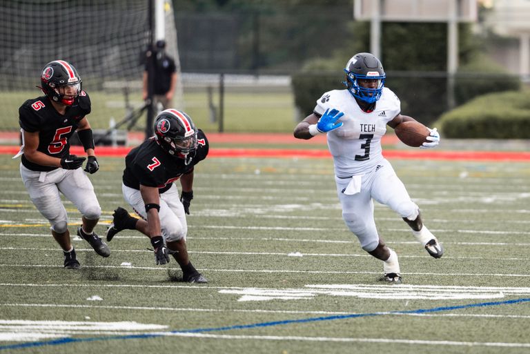 Dynamic action shot of an American football player evading opponents on a grassy field during a match.