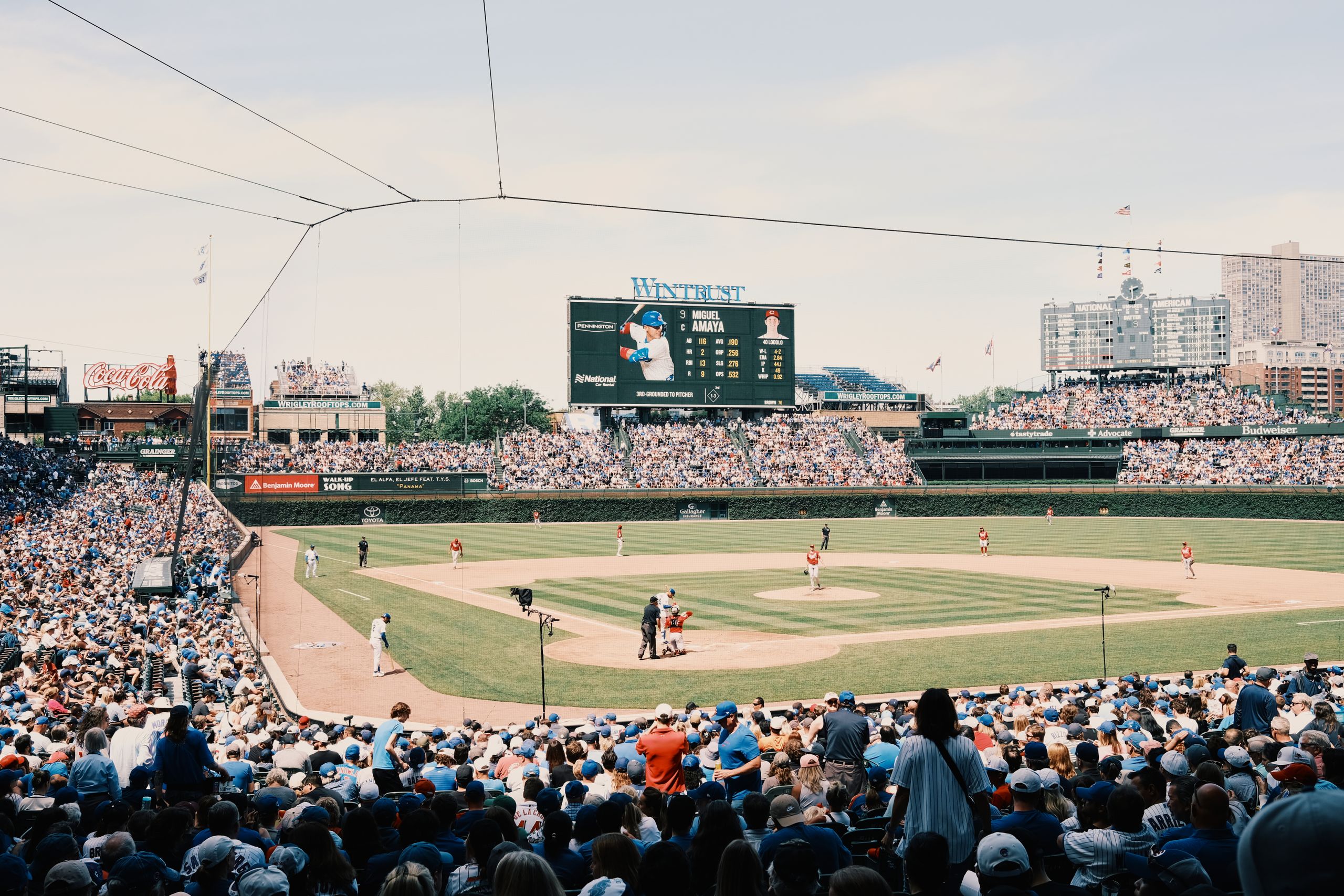 A lively baseball game at Wrigley Field with a packed stadium and urban skyline.
