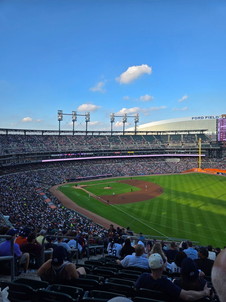 Crowded Comerica Park during an exciting baseball game under a clear blue sky.
