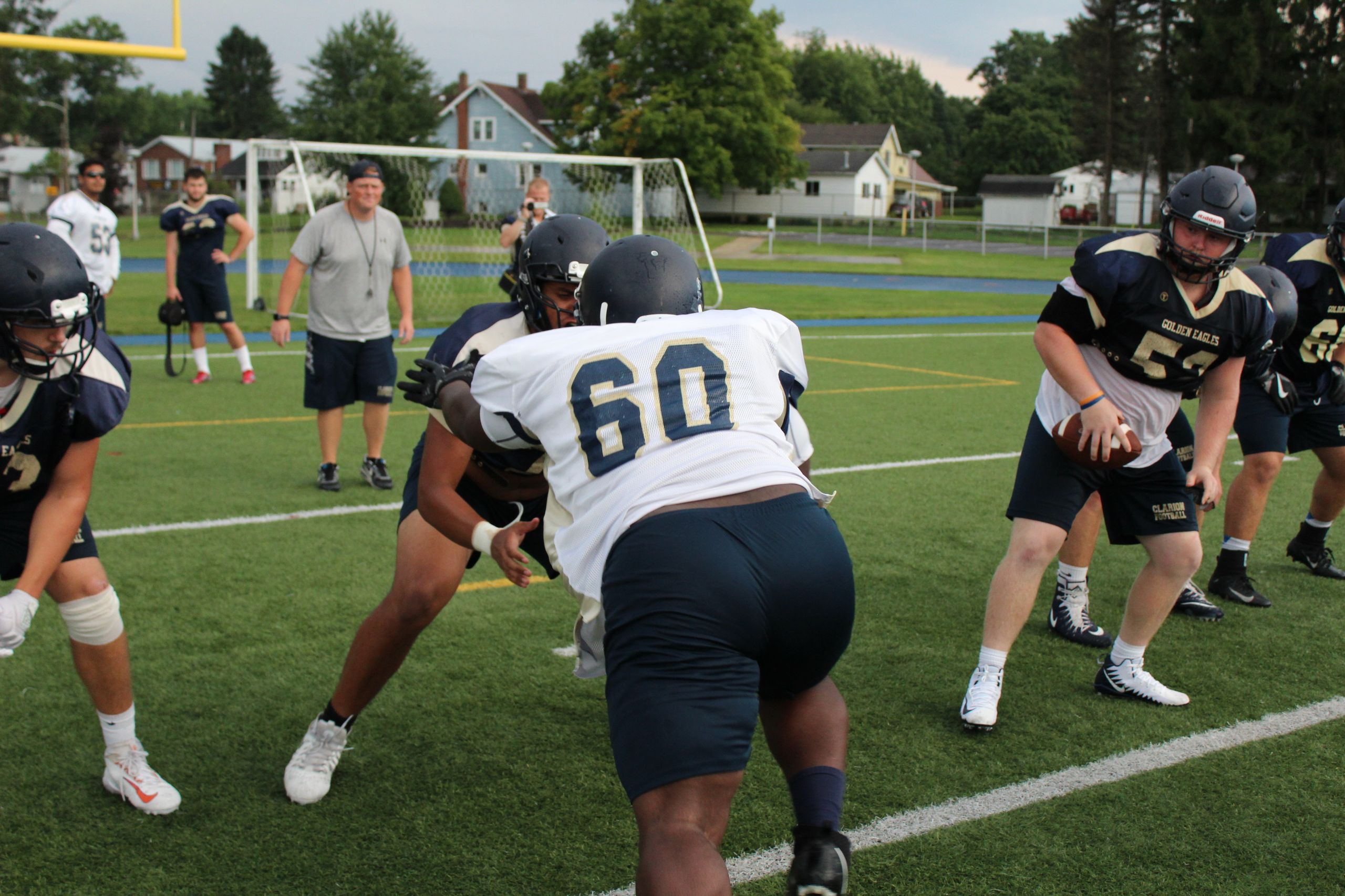 Dynamic scene of American football players in action during practice. Focus on teamwork and strategy.