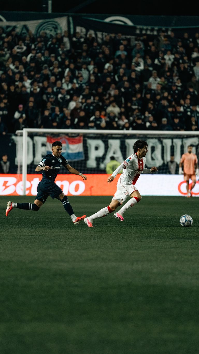 Exciting soccer game under the lights with two players in action on the field.