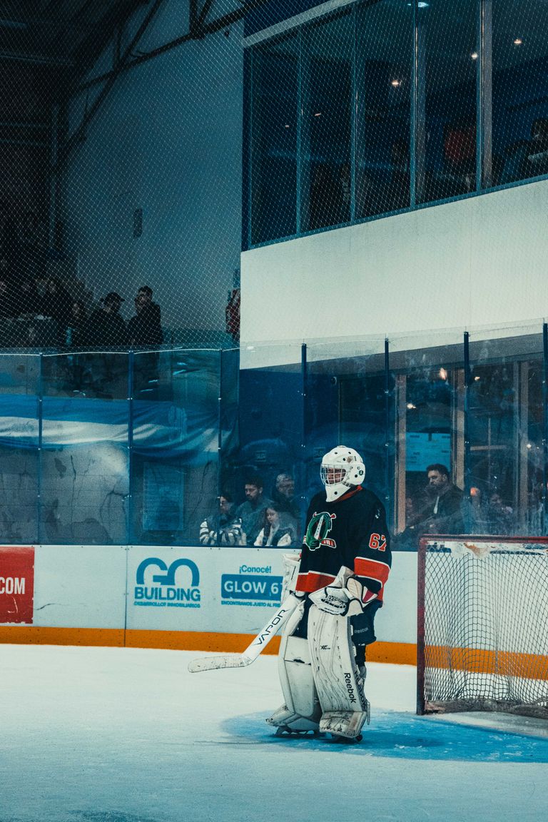 A focused ice hockey goalie standing guard in a Buenos Aires rink, ready for the shot.