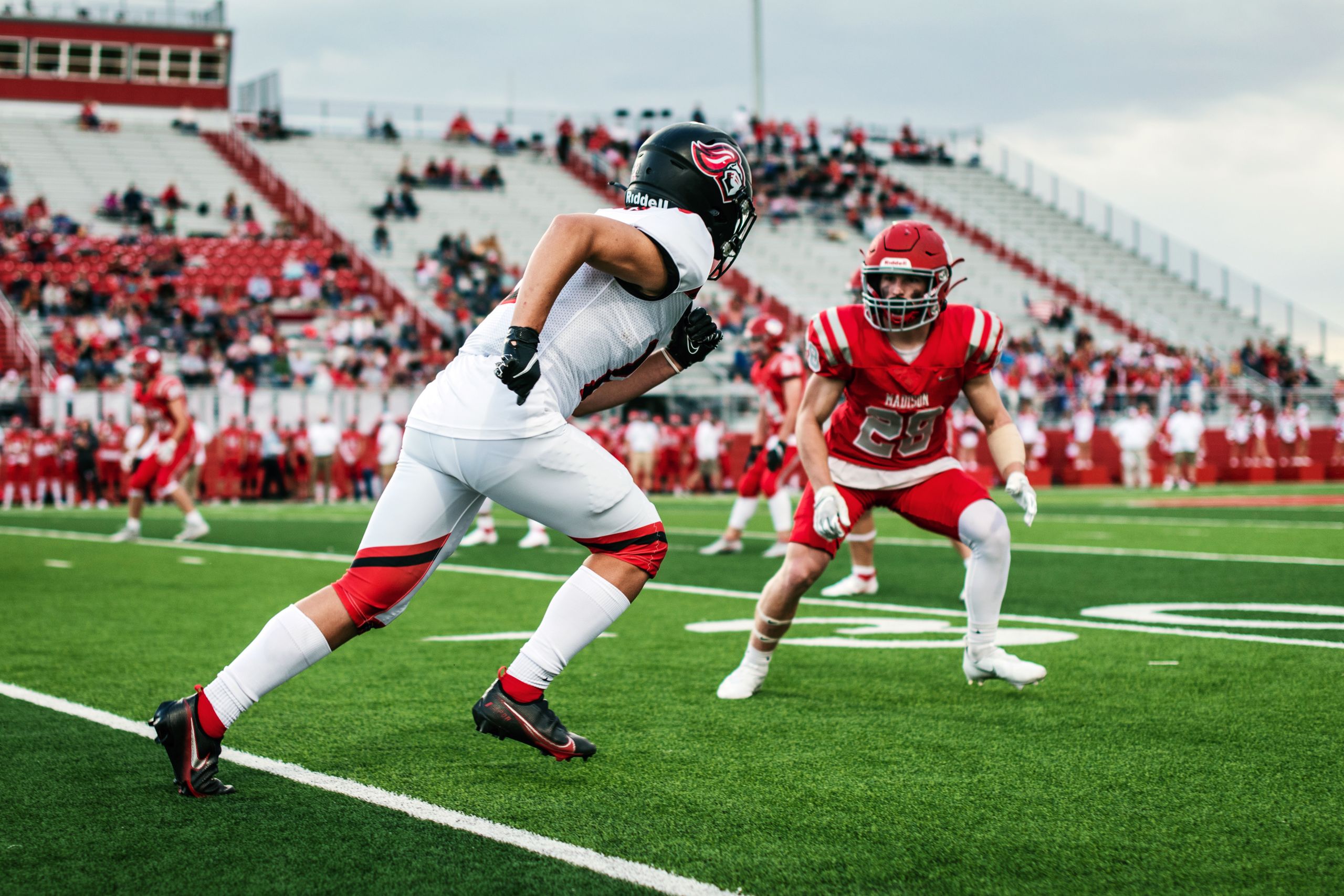 Intense American football match with two players facing off on a field.
