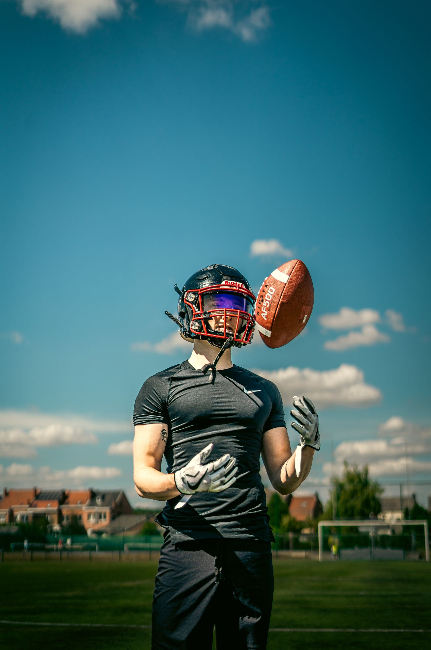 Athlete in helmet practices football outdoors, highlighting skill and focus.