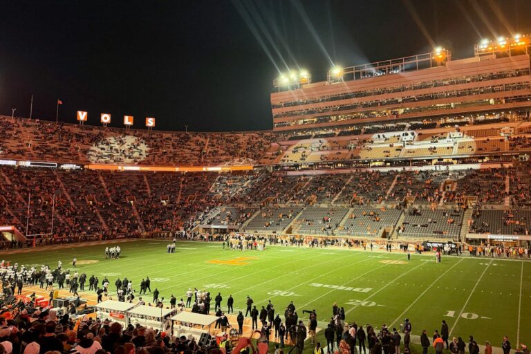 A crowded football stadium at night under bright lights