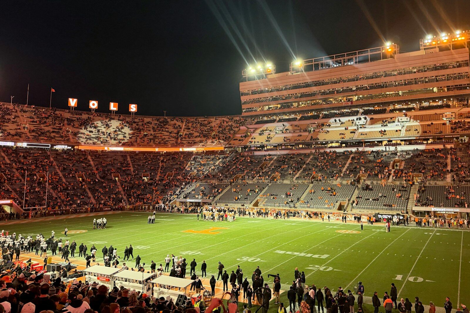 A crowded football stadium at night under bright lights