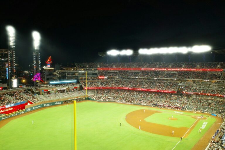 Crowded baseball stadium illuminated by bright lights at night