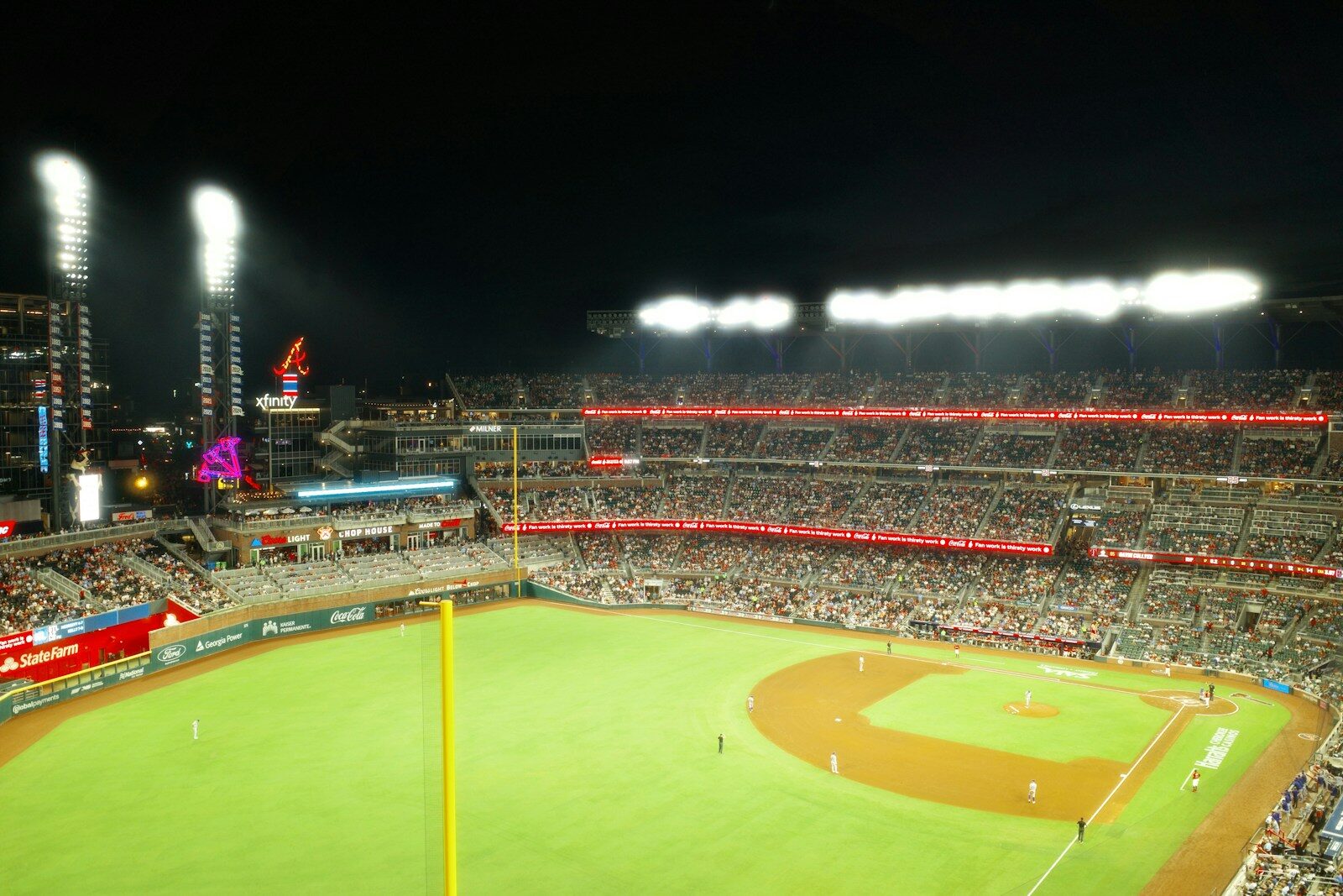 Crowded baseball stadium illuminated by bright lights at night