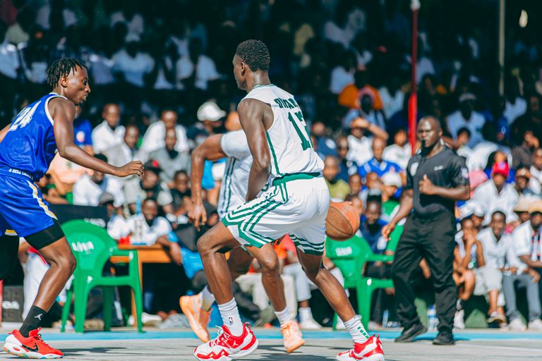 Dynamic outdoor basketball game with players competing fiercely in front of an engaged crowd.