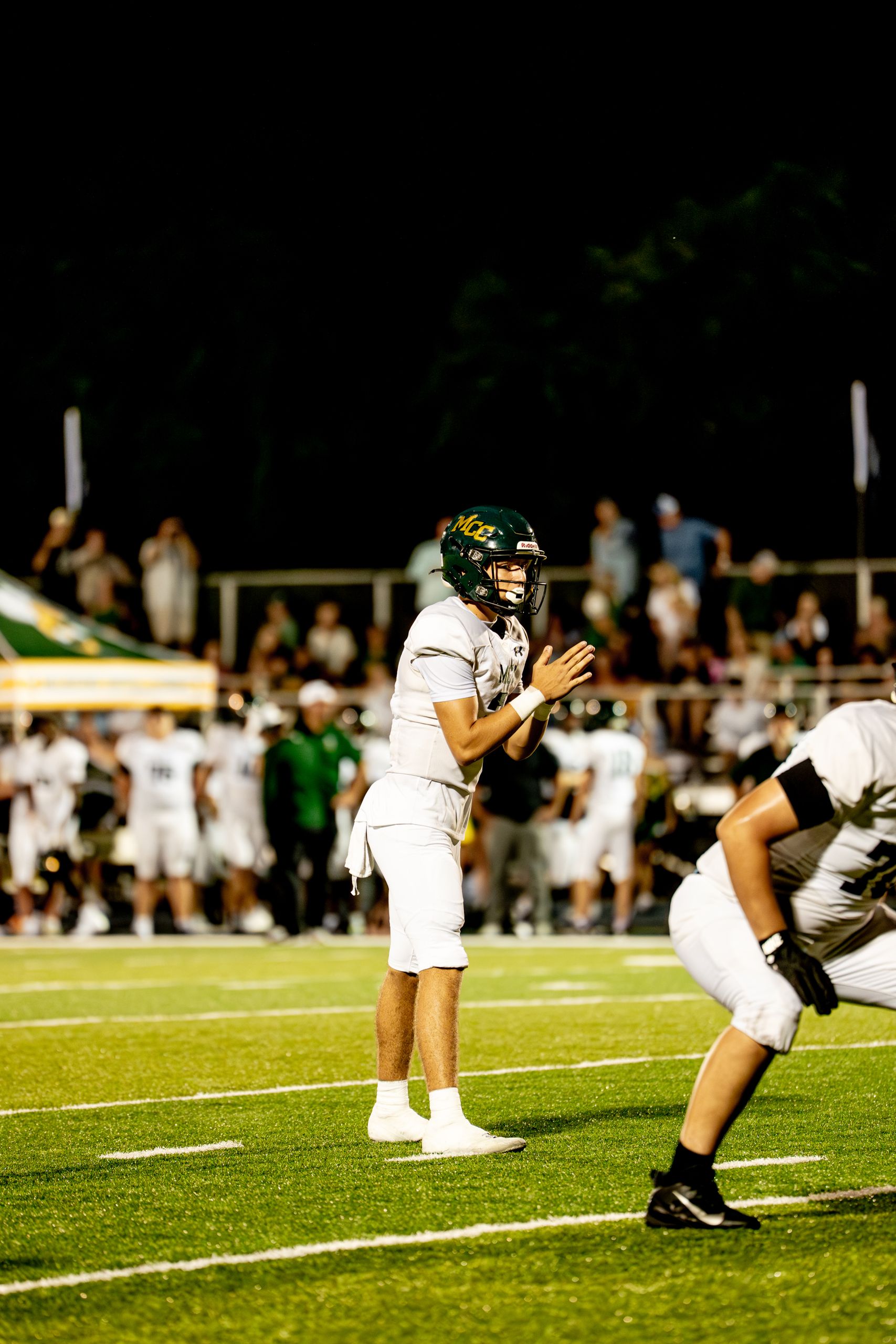 Exciting high school football game under the lights with focused players on the field.