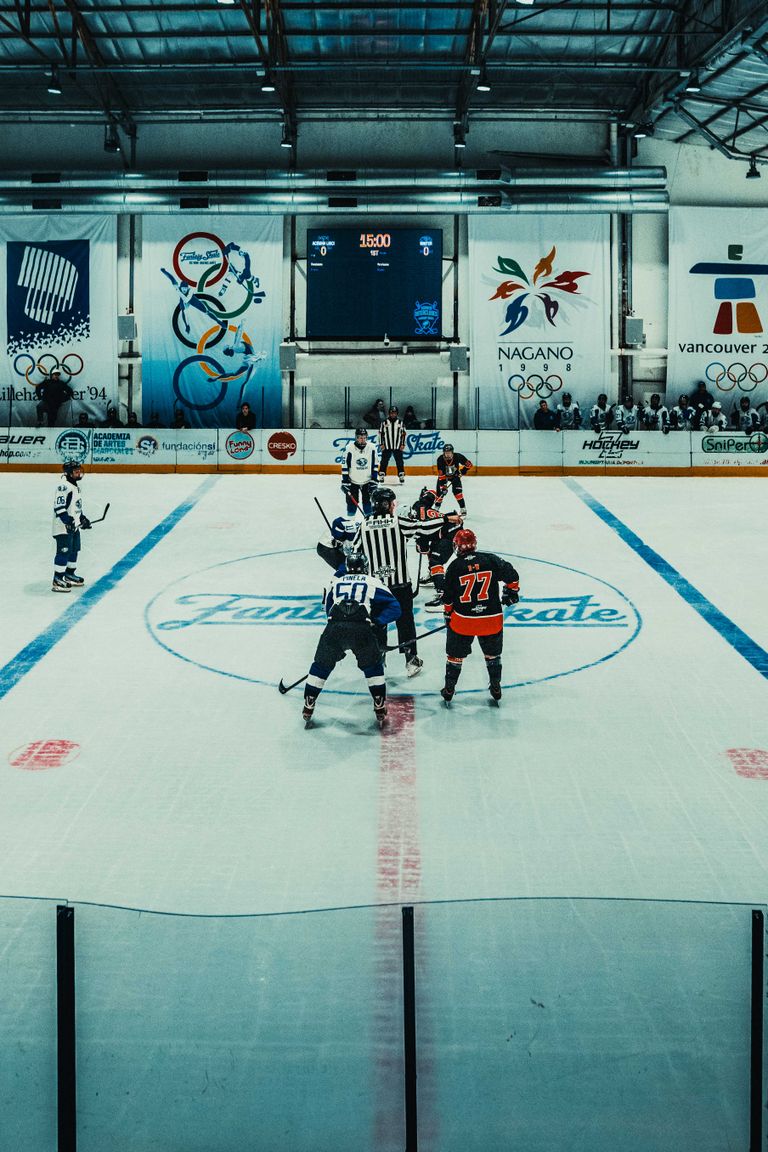 Exciting ice hockey match in Buenos Aires indoor rink, teams face off at center ice.