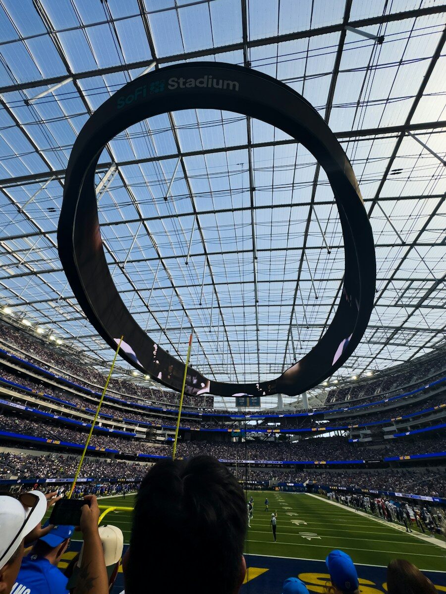 Circular scoreboard above a football stadium field